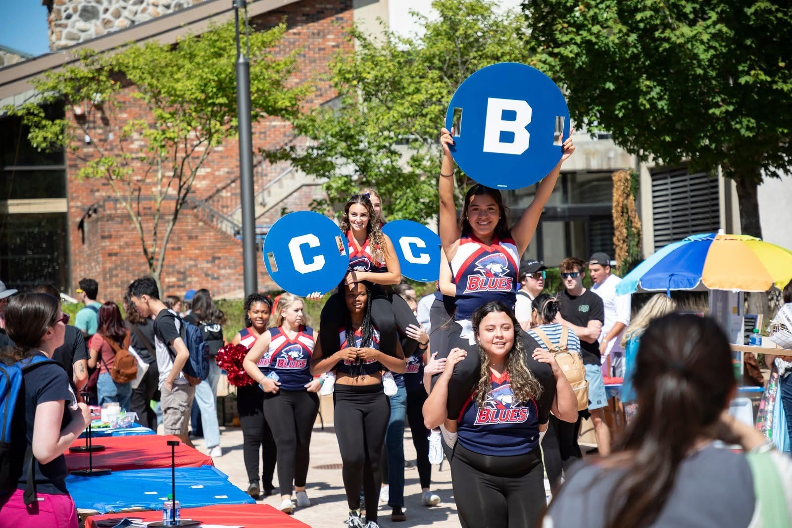 Cheerleaders at Brookdale event holding "B" "C" and "C" signs