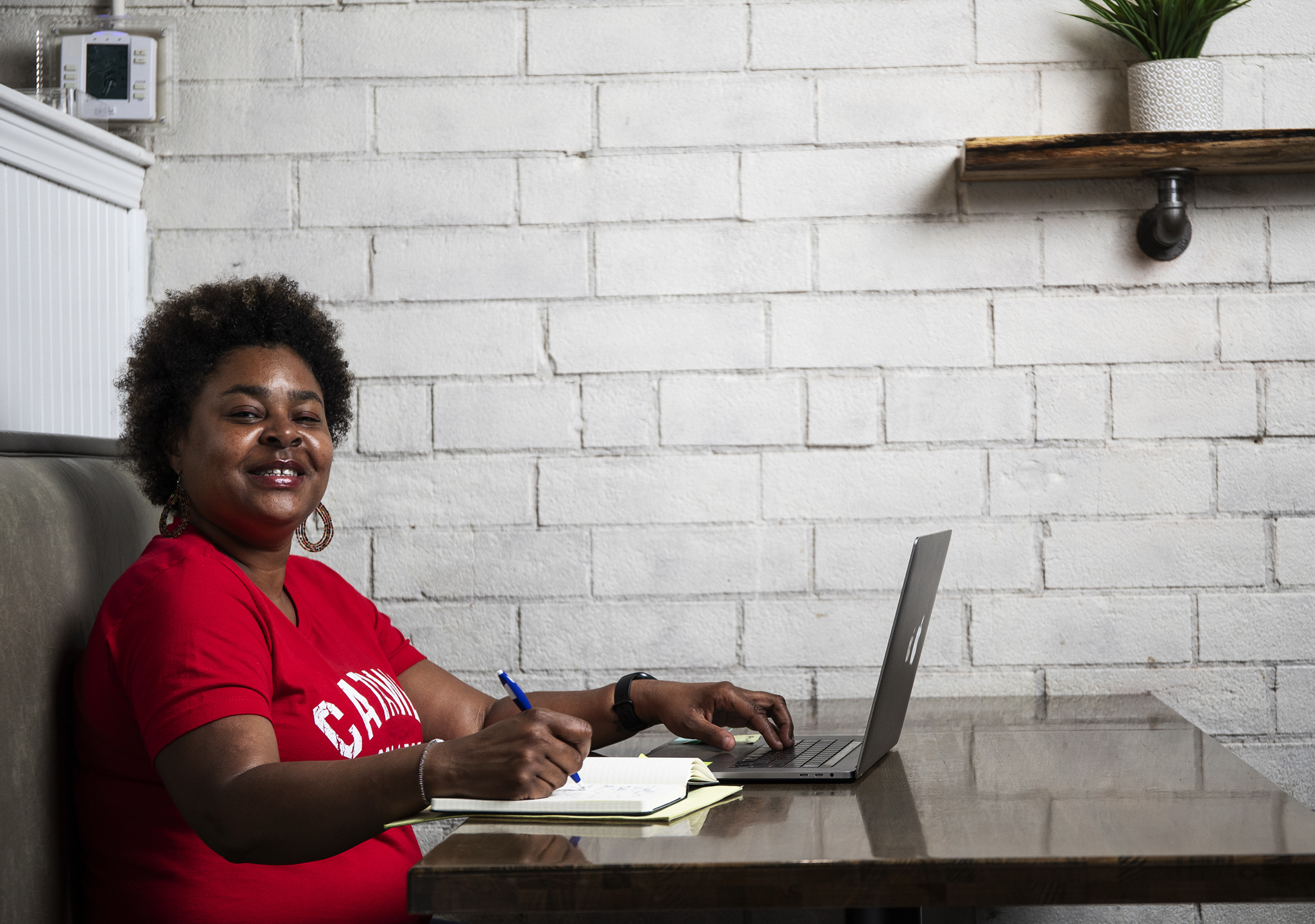 Online student on laptop working in a coffee shop