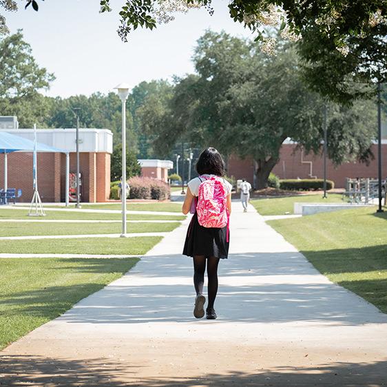 Student wearing a backpack walking on Lee Main Campus