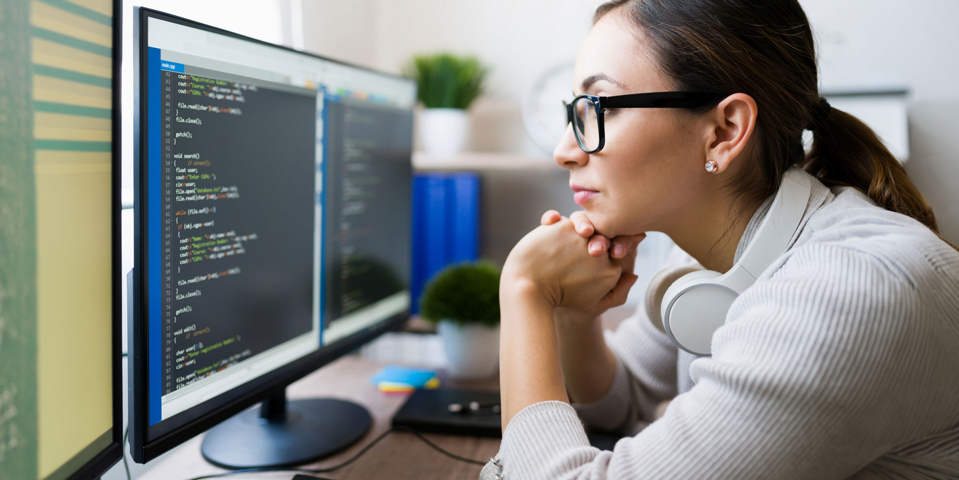 Woman working on computer coding on computer desktop