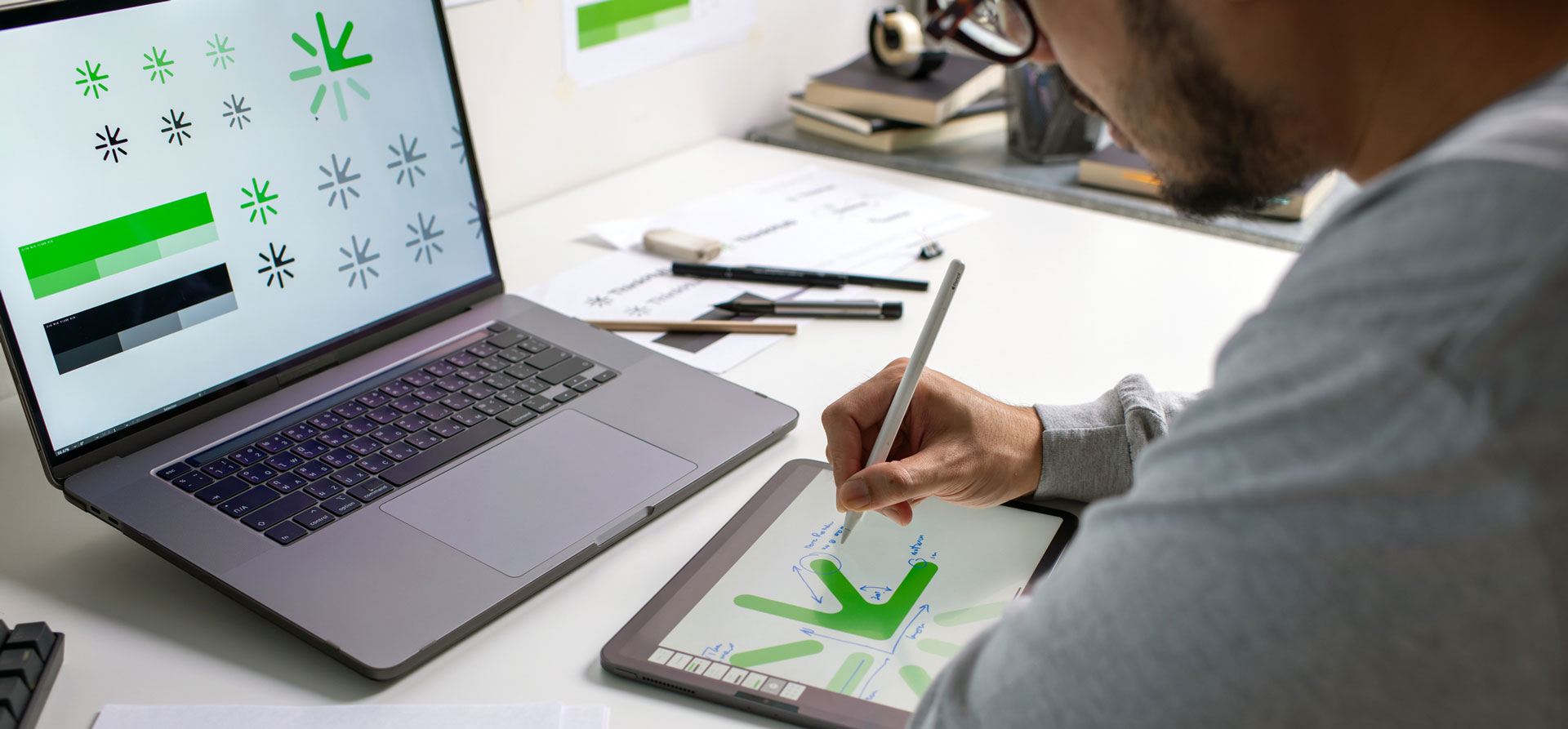 Man editing a green graphic image on a digital smart tablet