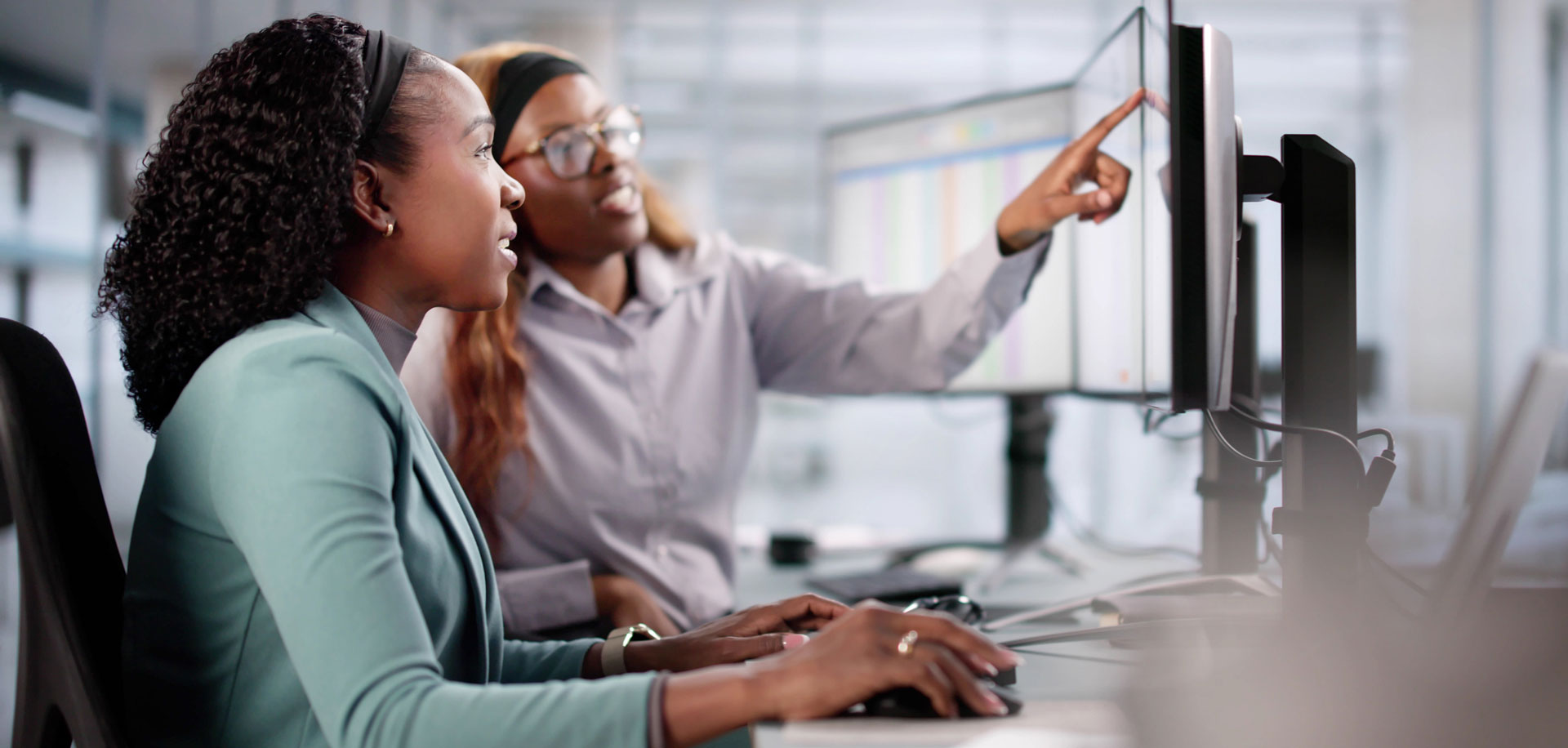Two women collaborating on a project using a computer