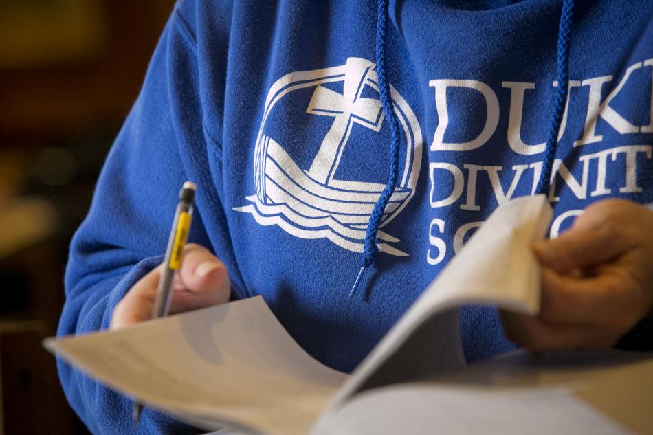 Close up of Duke Divinity student wearing a Divinity School sweatshirt studying in the York Room.