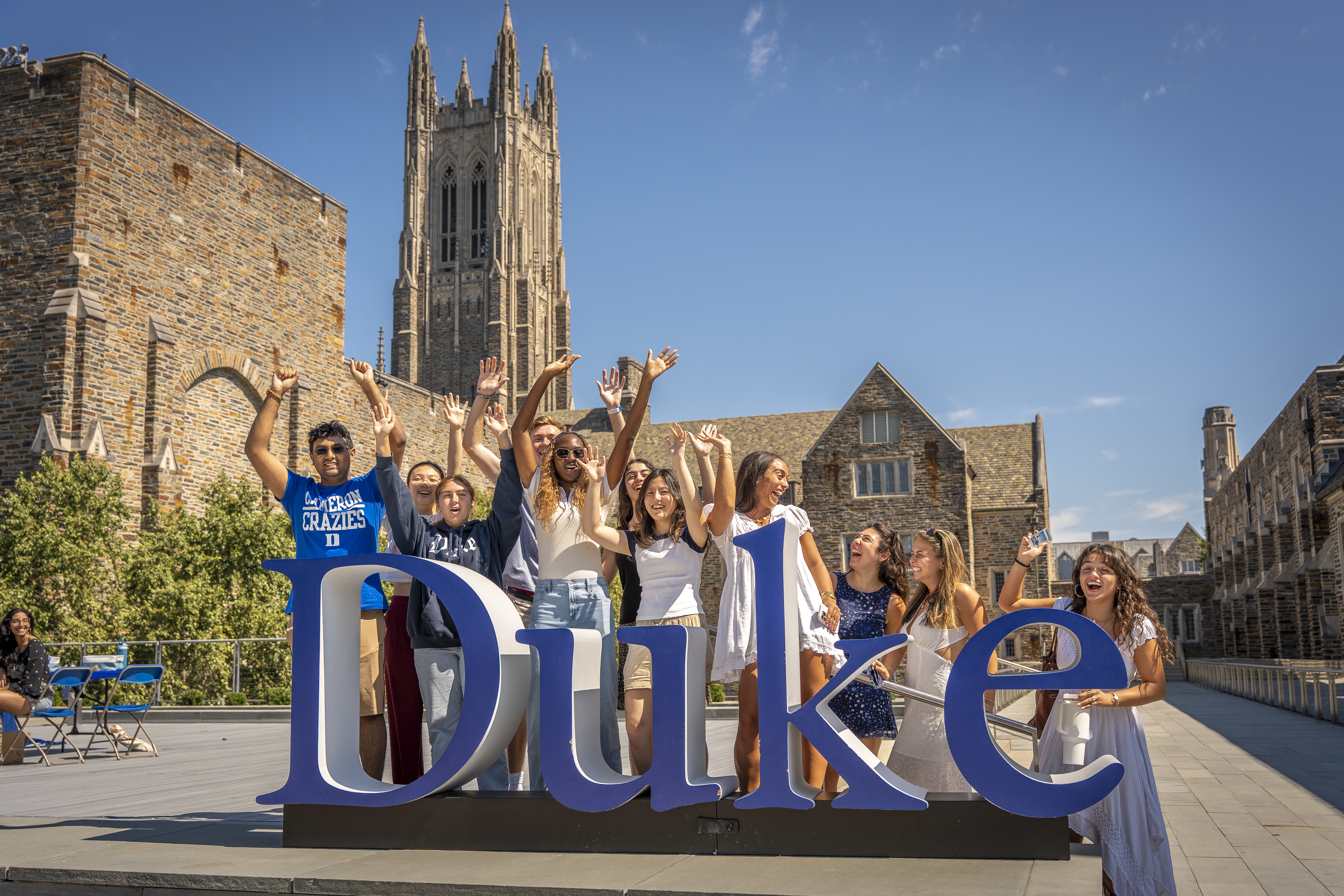 Students pose behind Duke logo.