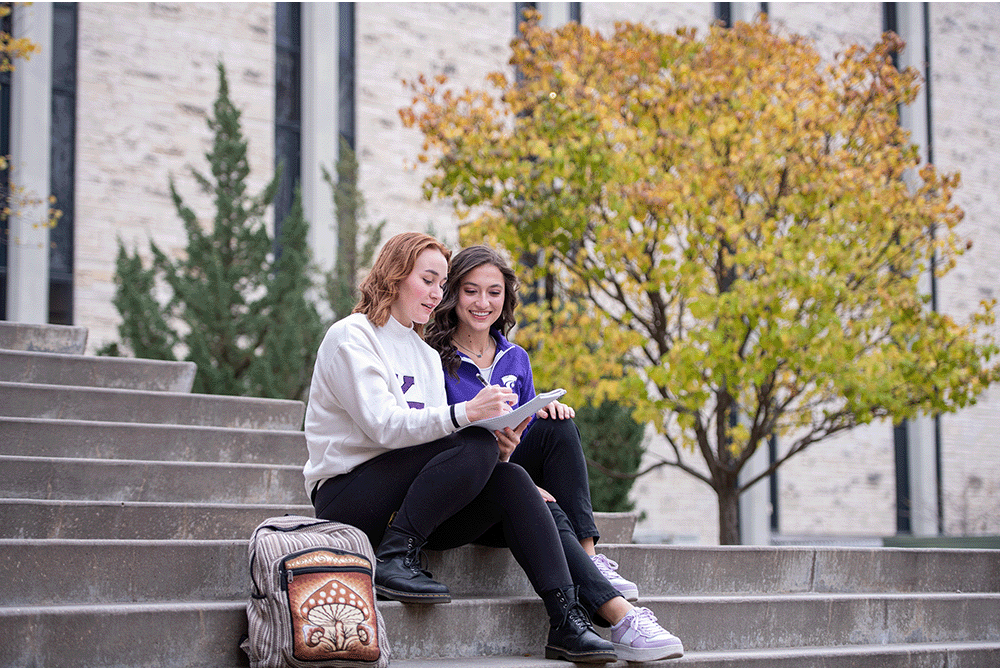 2 students sitting and looking at a paper
