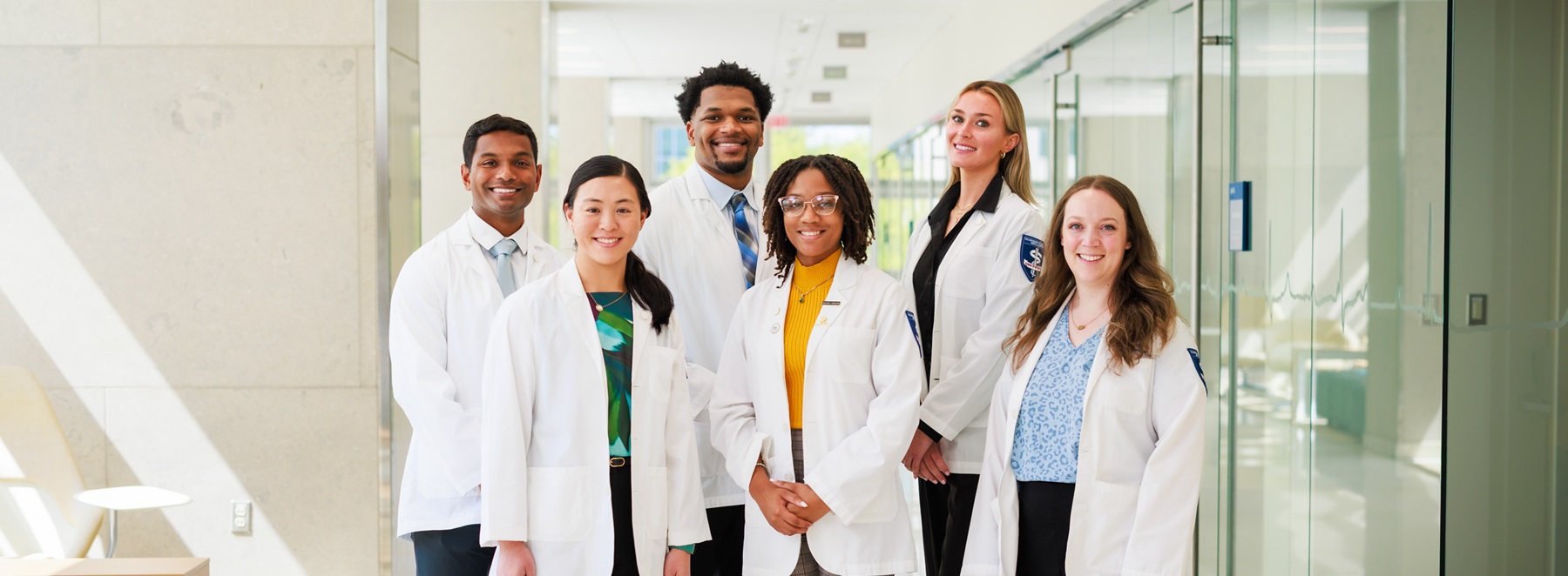 A group of SOM students in white coats.
