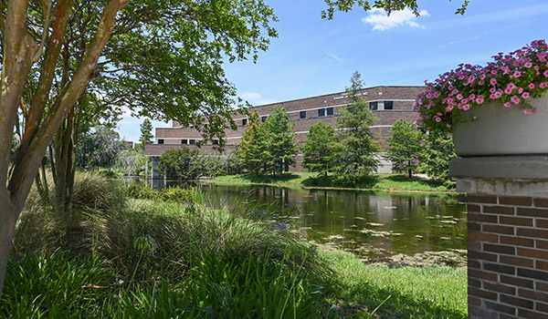 Campus landscape with Coggin Business College across water